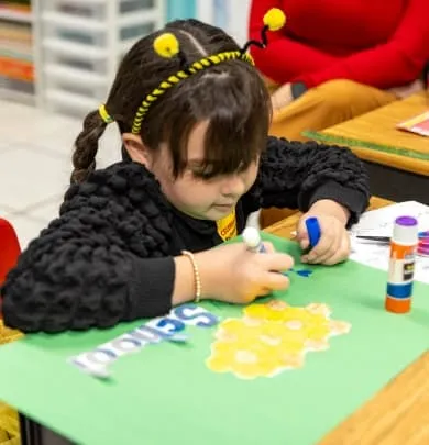 Preschool child working on a craft project in a Miami daycare classroom