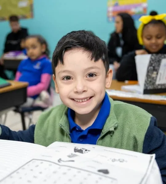 Smiling student reading in an inclusive classroom